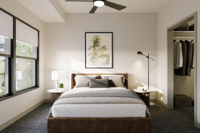 Modern bedroom with a neatly made bed, two side tables, and an open closet on the right.